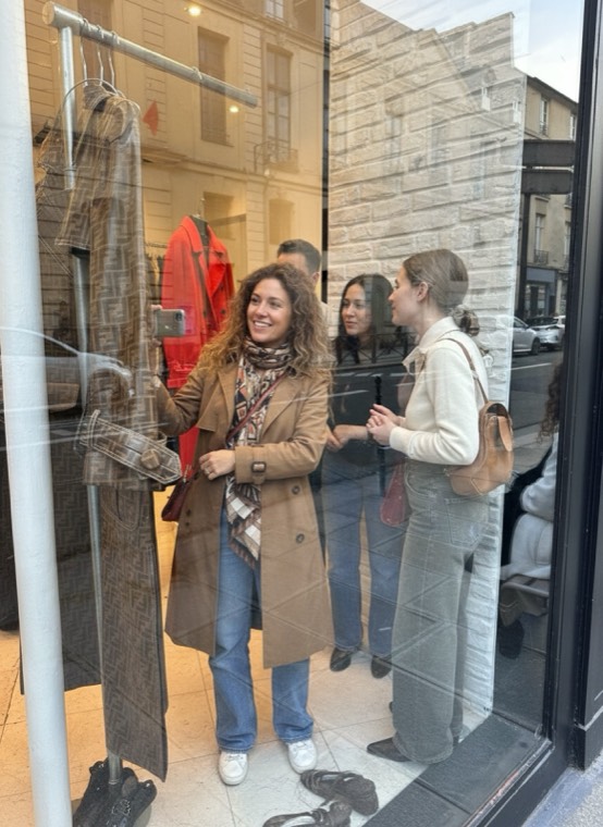 Guests chatting in a vintage shop window on a Paris street