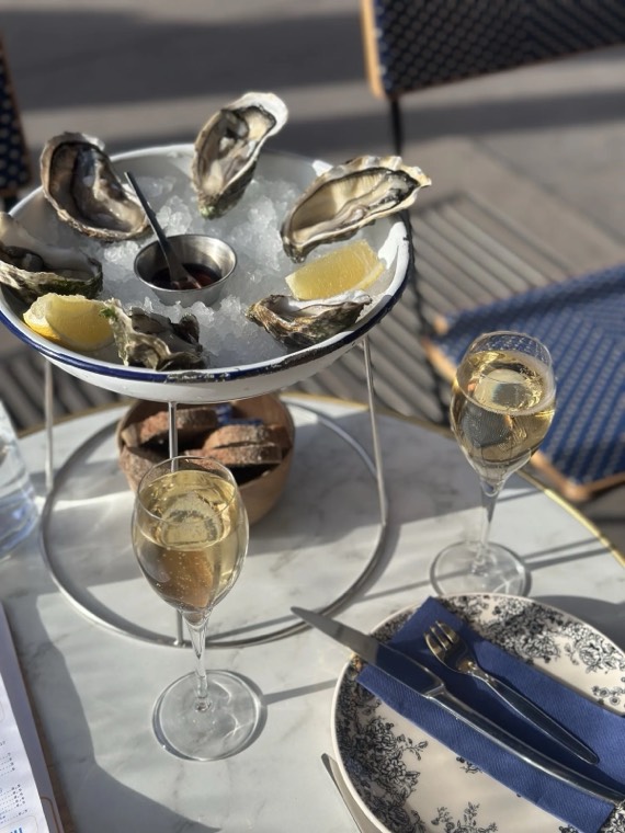 Oysters on a stand beside glasses of Champagne