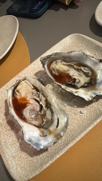 Two oysters served with a red mignonette on a plate
