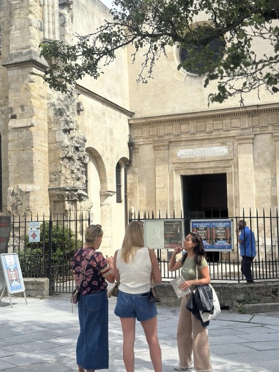 Guests standing outside a stone building with an iron fence in Paris