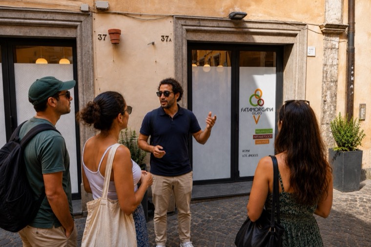 A guide talking with guests outside a shop in Rome