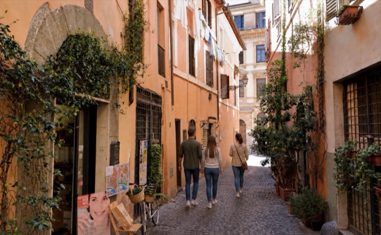 A quiet cobbled alley lined with ivy in Rome