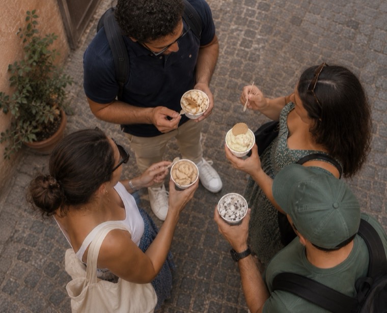 An overhead view of guests eating gelato on cobblestones